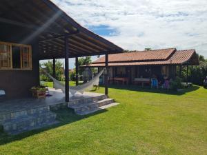a house with a porch with a hammock in the yard at Cantinho do paraíso in Gamboa