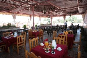 a restaurant with tables and chairs and people in the background at Hotel Ichbilia فندق اشبيلية in Marrakesh