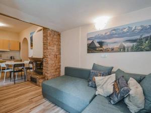 a living room with a blue couch and a kitchen at Apartamenty Góralska Pasja Krupówki 37 in Zakopane