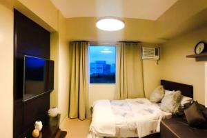 una piccola camera con letto e finestra di Zen Living Condo at Avida Atria Tower 2 a Città di Iloilo