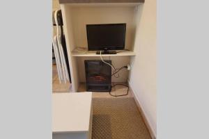 een tv op een plank in een kamer bij Studio idéalement situé in Cauterets