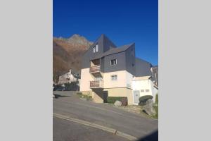 een groot wit huis aan de kant van een weg bij Studio idéalement situé in Cauterets