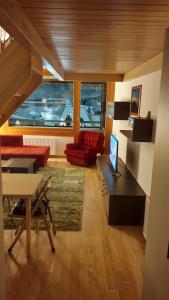 een woonkamer met een rode bank en een tafel bij Winter dream Bjelasnica in Bjelašnica