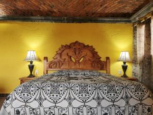 - une chambre avec un grand lit et deux lampes dans l'établissement Posada Casa del Minero, à Mineral de Pozos