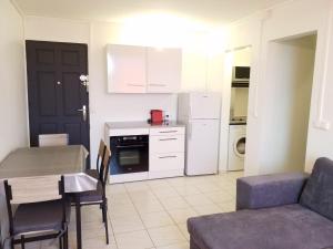 a kitchen and living room with a table and a couch at Appartement Centre Guadeloupe, accessible et proche in Les Abymes