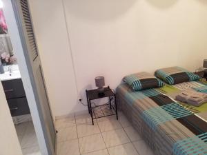 two twin beds in a small room with a table at Appartement Centre Guadeloupe, accessible et proche in Les Abymes