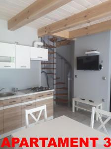 a kitchen with a sink and a stove top oven at KOPALINO Apartamenty nad morzem in Kopalino