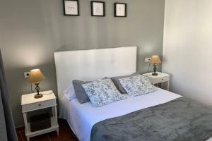 a bedroom with a bed with two night stands and two lamps at Apartamento Bastian Casas Verdes in Costa Teguise +52 photos