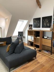 a living room with a grey couch in a attic at RaumAusbeute Design Apartment Hoher Priester in Detmold