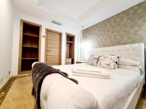 a bedroom with a large white bed in a room at Puerto Banús Beach Apartments in Marbella