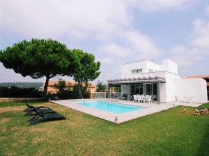 a villa with a swimming pool in front of a house at Villa Gregal in Son Bou