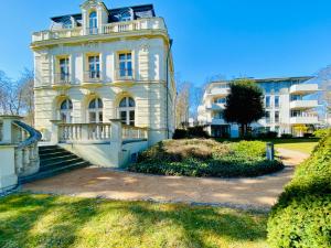 a large white building with a staircase in front of it at Residenz Bleichröder - Ferienwohnung 18 in Heringsdorf