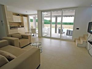 a living room with a couch and a table and a kitchen at Villa Gregal in Son Bou