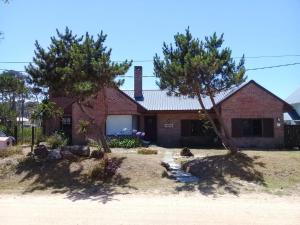 ein Backsteinhaus mit zwei Bäumen davor in der Unterkunft Montoya Jazmin in Punta del Este