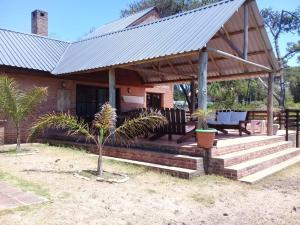 ein Haus mit einem Metalldach und einer Veranda in der Unterkunft Montoya Jazmin in Punta del Este