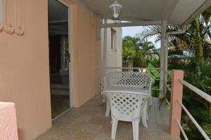 a white table and chair on a balcony at Appartement de Standing en Martinique in Schœlcher