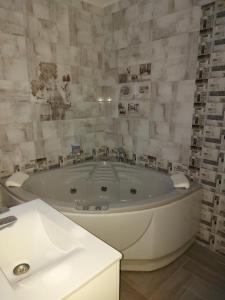 y baño con bañera blanca y lavamanos. en Sweet Life Family Hotel, en Tsigov Chark