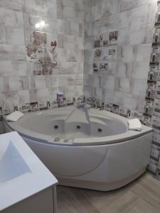 a large white bath tub in a bathroom at Sweet Life Family Hotel in Tsigov Chark