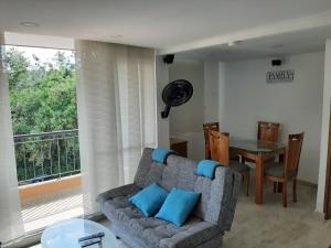 - un salon avec un canapé, une table et une fenêtre dans l'établissement Apartamento familiar para un buen descanso con WiFi, à Ricaurte