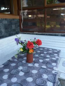 a table with a vase with flowers on it at Sweet Life Family Hotel in Tsigov Chark