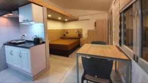 eine kleine Küche mit einem Tisch und ein Zimmer mit einem Bett in der Unterkunft Studio Mangales in Santa Cruz de la Sierra