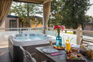 une baignoire jacuzzi installée au-dessus d'un patio dans l'établissement Premium Camping Homes Santa Marina, Lanterna, à Poreč