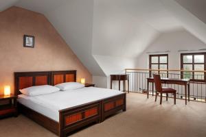 um quarto com uma cama, uma secretária e uma varanda em Hotel Javor em Adrspach