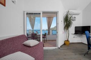 a living room with a couch and a view of the ocean at BeachView Apartments in Drasnice in Drašnice