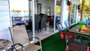 a screened in porch with chairs and a table at 3000 Sq Ft Beach and Bay Condo in St Pete Beach