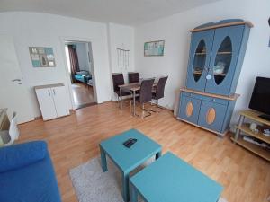 ein Wohnzimmer mit einem blauen Schrank und einem Tisch in der Unterkunft Ferienwohnung Maritim mit E-Bike Verleih in Wilhelmshaven