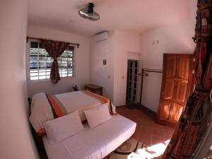 a bedroom with a bed and a couch and a window at Casa Lomas del Marinero Internet Starlink SIN GARAJE in Puerto Escondido