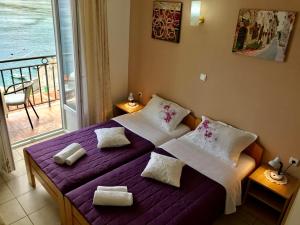 a bedroom with a purple bed and a balcony at Apartments Okuka in Tivat