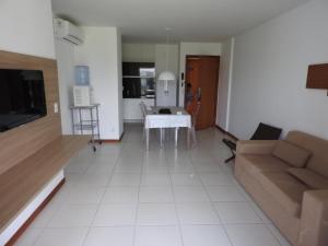 Apartamento excelente e espaçoso no Iloa Residence في بارا دي ساو ميجيل: غرفة معيشة مع طاولة وأريكة