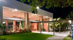 Apartamento excelente e espaçoso no Iloa Residence في بارا دي ساو ميجيل: مبنى كبير مع حديقة أمامه