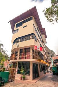 a tall building with a balcony on a street at Samananchis Machupicchu in Machu Picchu