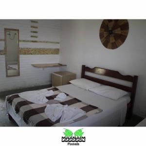 a bedroom with a bed with towels on it at Pousada Maanaim in Ubatuba