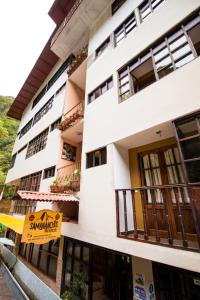 un edificio blanco con un cartel delante en Samananchis Machupicchu, en Machu Picchu