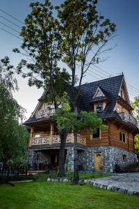 una gran casa de madera con techo negro en Góralski Spa - Luksusowa willa z sauną i wanną z hydromasażem, en Kościelisko