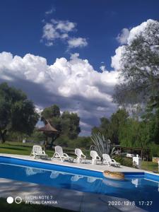 a group of chairs and a swimming pool at POSADA EN LAS TAPIAS TRANSLASIERRAS in Las Tapias