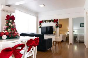 ein Wohnzimmer mit einem Weihnachtsbaum und einer Couch in der Unterkunft SANTA CLAUS 2 - Centro de Gramado in Gramado