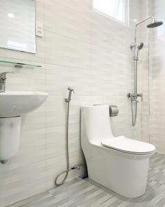 ein weißes Bad mit einem WC und einem Waschbecken in der Unterkunft Street View Hotel & Apartment in Da Lat