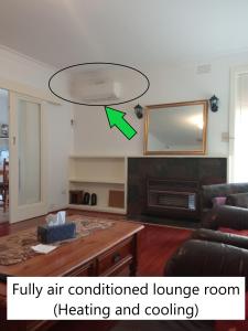 een lounge met airconditioning en een lichtinstallatie bij Sunny House - Melbourne Airport Home in Melbourne