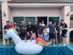 a group of people posing for a picture next to a pool at Pattaya Pool Villa in Jomtien Beach