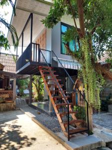 a staircase leading up to a house with a tree at kwanlah homestay in Mae Chaem