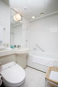 a bathroom with a toilet and a sink and a tub at JR Tower Hotel Nikko Sapporo in Sapporo