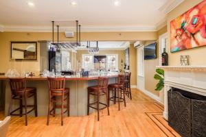 a kitchen with a bar with stools and a fireplace at Simsbury 1820 House in Simsbury