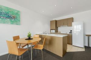 cocina y comedor con mesa y sillas en Wallaroo Marina Sea Vu Apartment en Wallaroo