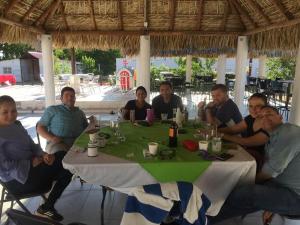 Eine Gruppe von Menschen sitzt um einen Tisch in der Unterkunft Catorce Capital A una HORA de Real de Catorce in Estación Catorce