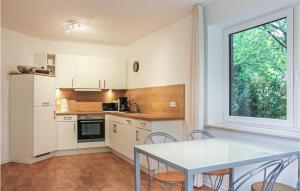 Lovely Apartment In Bockhorn With Wifi في بوكهورن: مطبخ مع طاولة وكراسي ونافذة