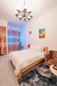 a bedroom with a large bed and a chair at Lumos Home Ha noi in Hanoi